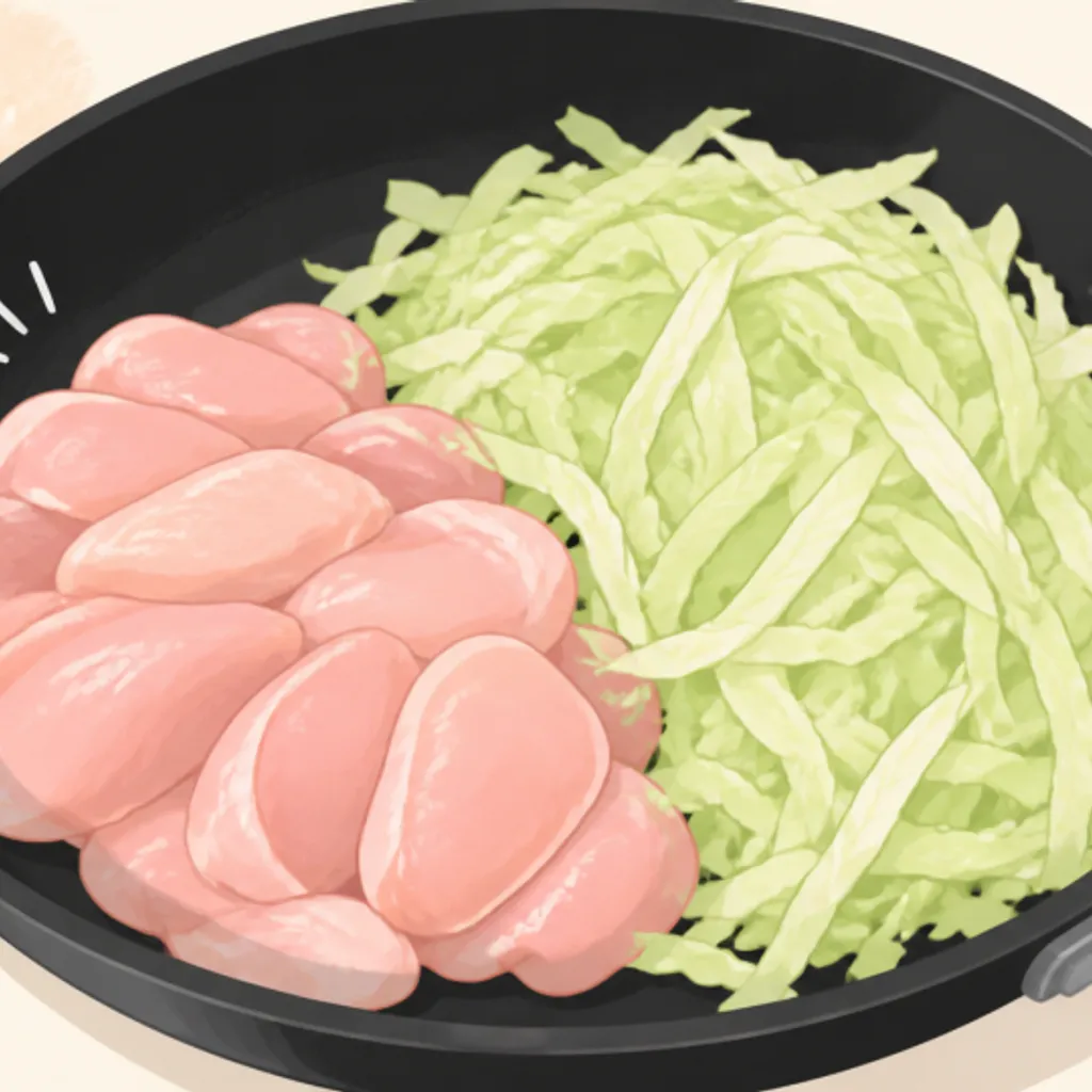 フライパンに入れた鶏むね肉とキャベツ